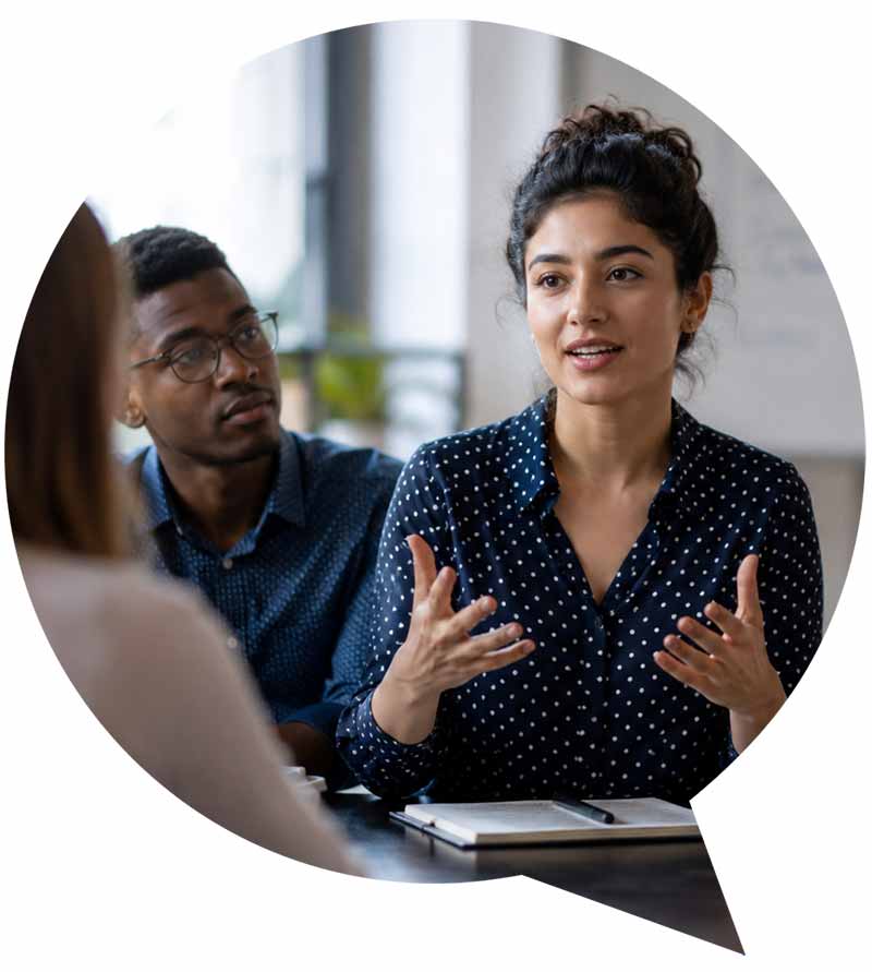Young professional speaking confidently as colleagues listen during a group discussion Title: